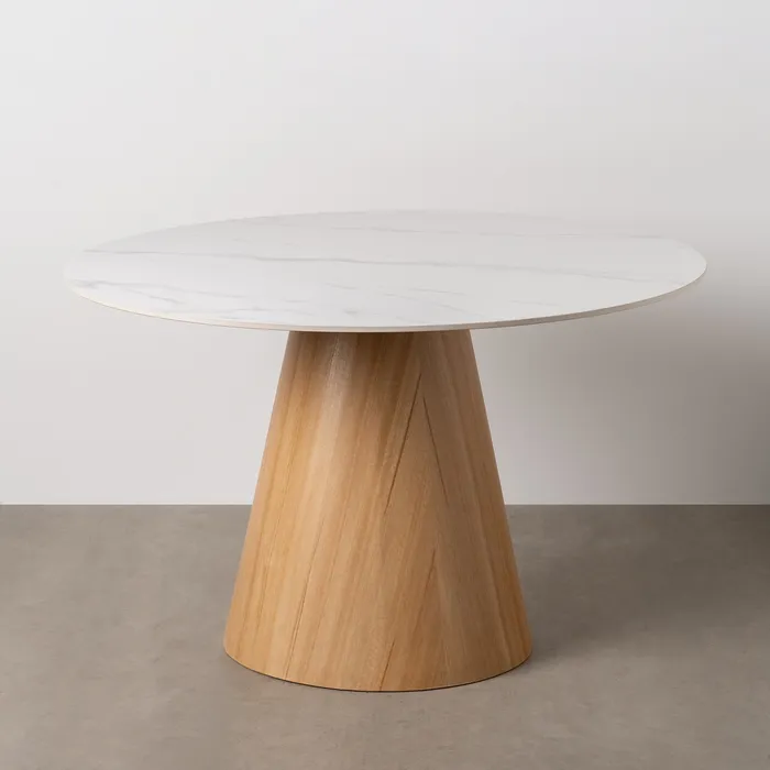 Mesa redonda con superficie de efecto mármol y elegante base de madera, una opción moderna y sofisticada, disponible en Artisa